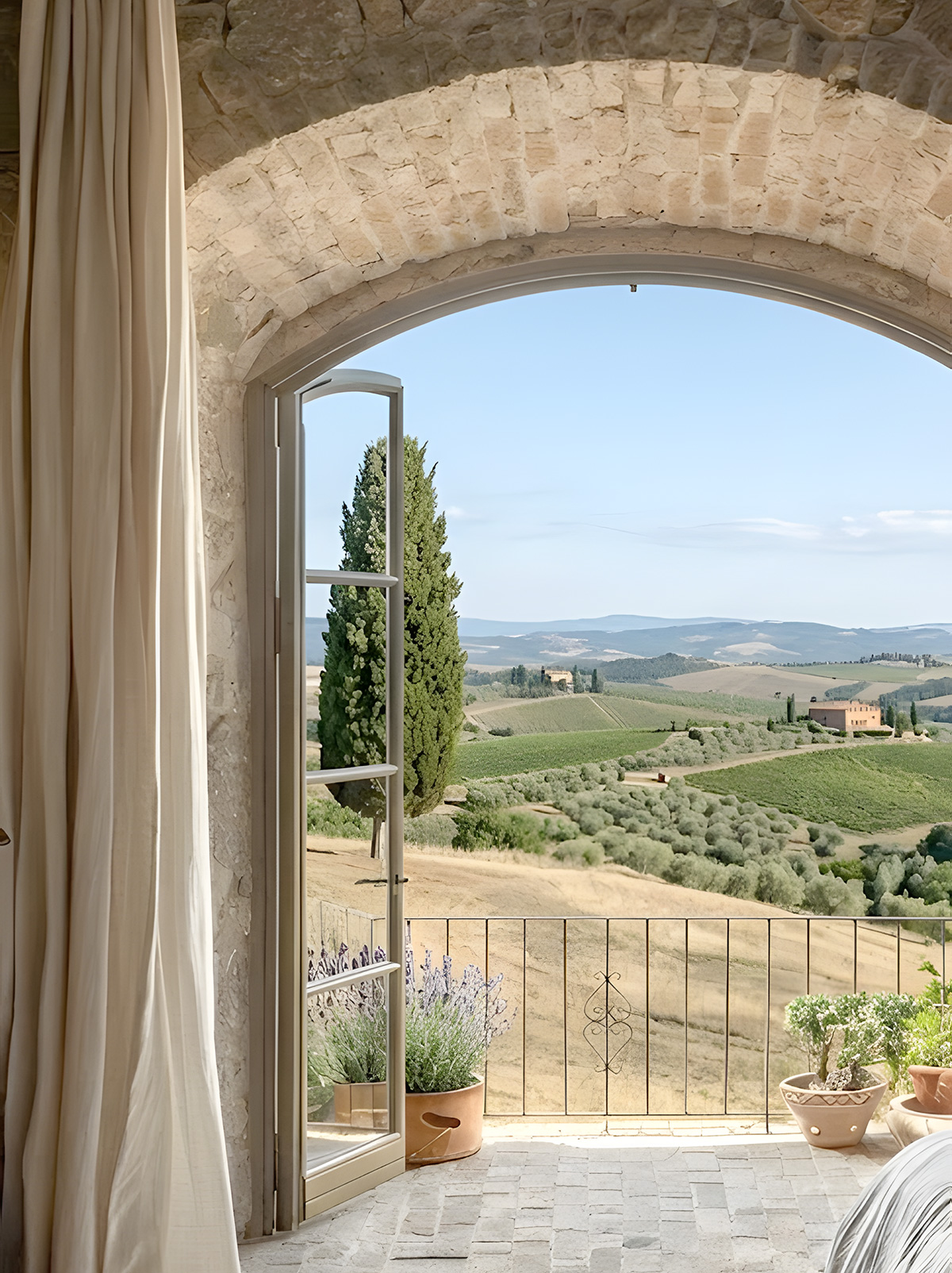 Minimalist bedroom in a historic Tuscan home overlooking the countryside