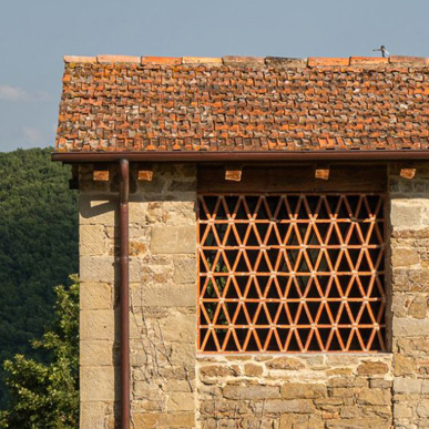 Detail of a traditional Tuscan farmhouse with stone walls, terracotta and mandolata overlooking the countryside